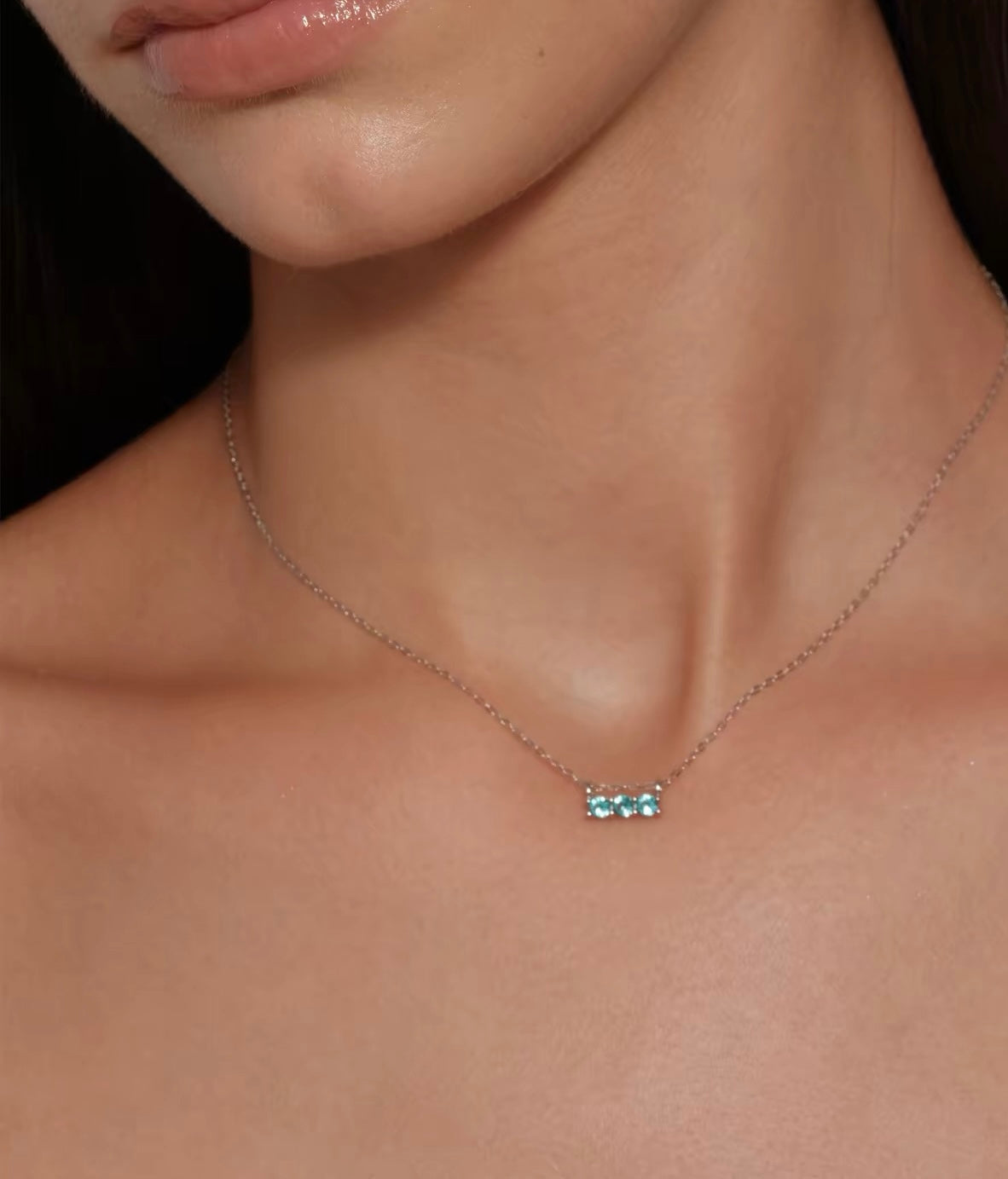 Model wearing aqua blue three-stone necklace