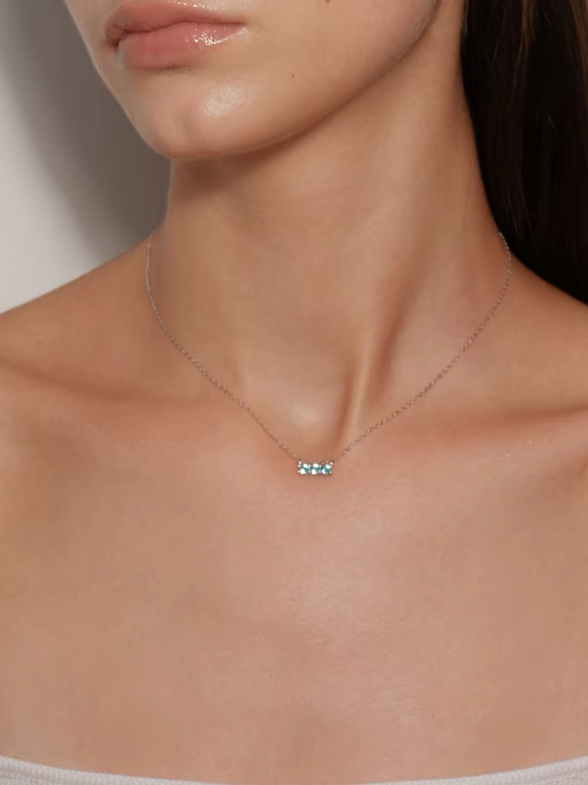 Model wearing aqua blue three-stone necklace