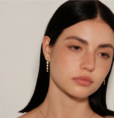Model wearing Cascade Earrings in gold, close beauty portrait