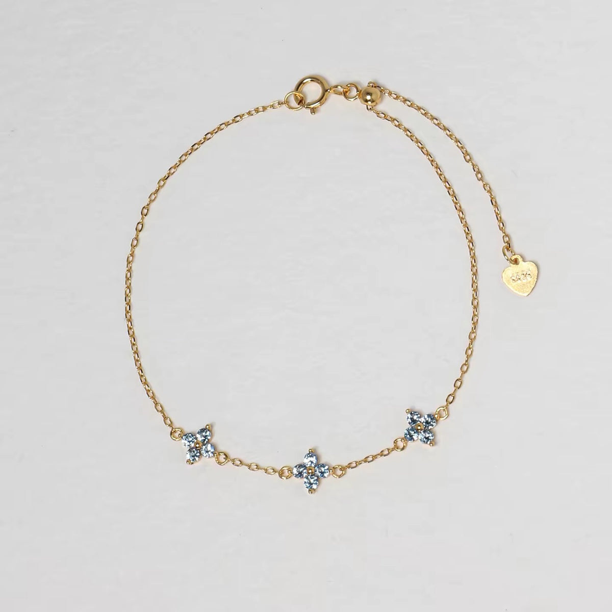 Clover Bracelet in gold with three pale blue four-petal floral stones