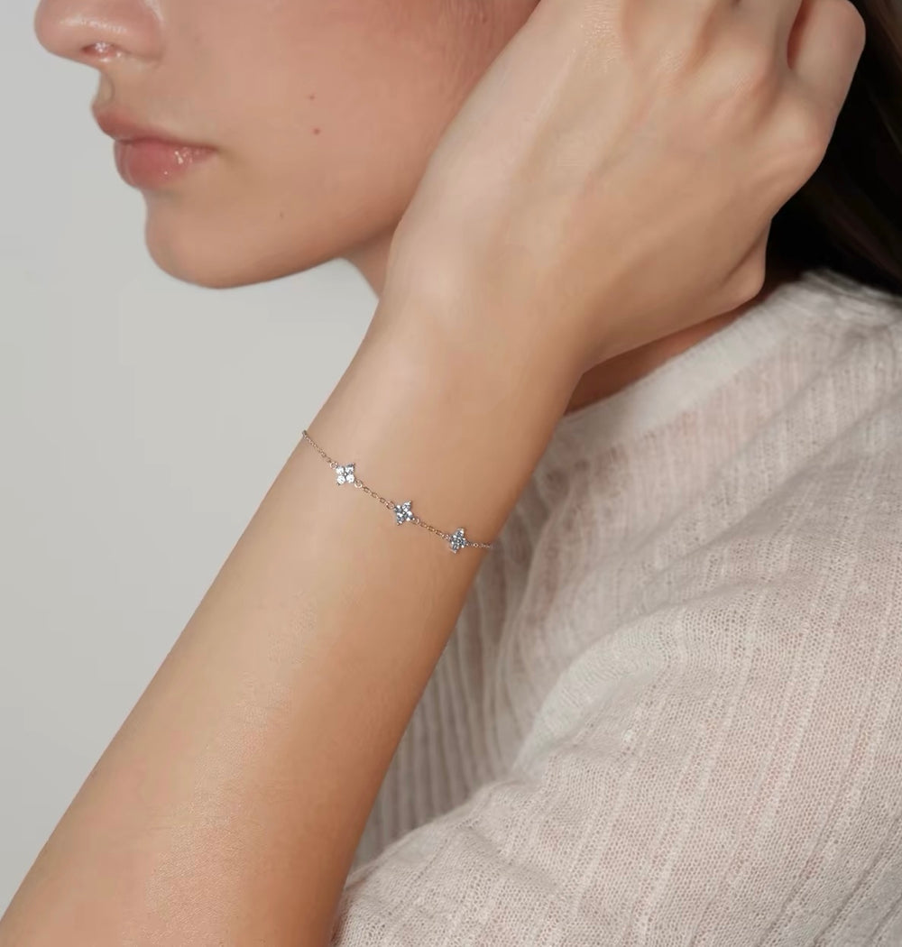 Model wearing silver Clover Bracelet with three pale blue floral stones