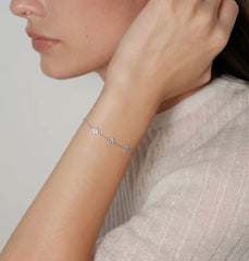 Model wearing silver Clover Bracelet with three pale blue floral stones