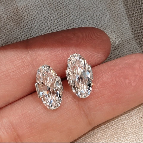 Éclat Ovale earrings shown on hand for scale