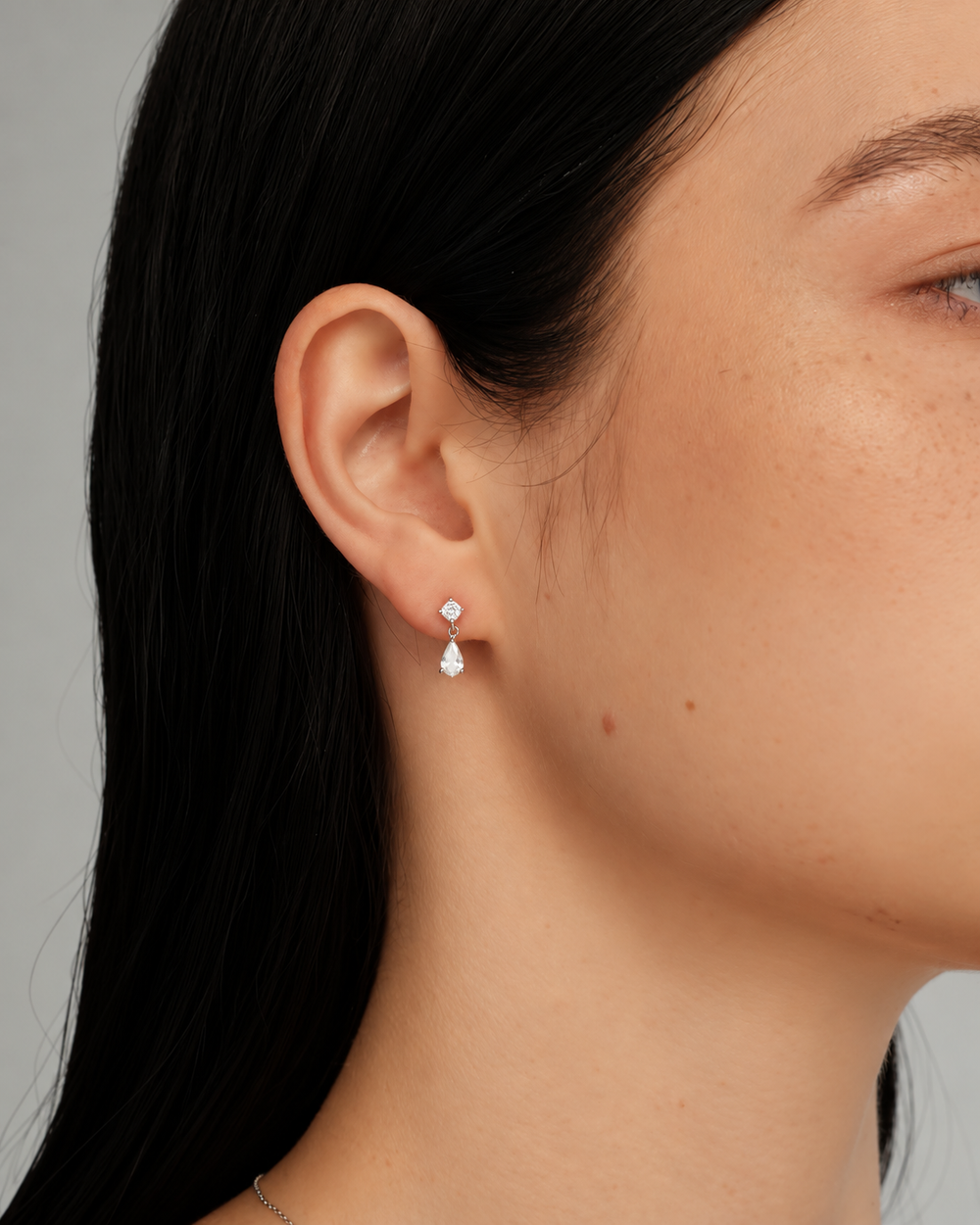 Model wearing silver Dew Earrings, tightly cropped side portrait