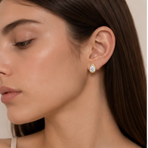 Model wearing Goutte Éclat gold pear-shaped stud earring, side portrait