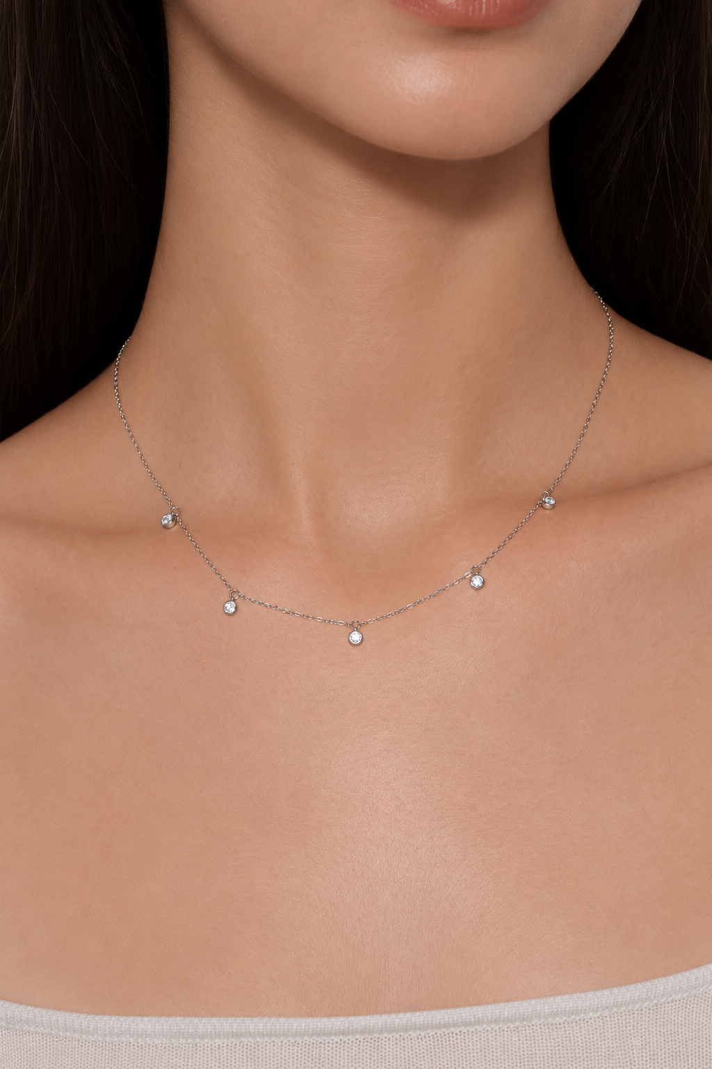 Close-up of Pluie de Lumière Necklace in silver worn at the collarbone